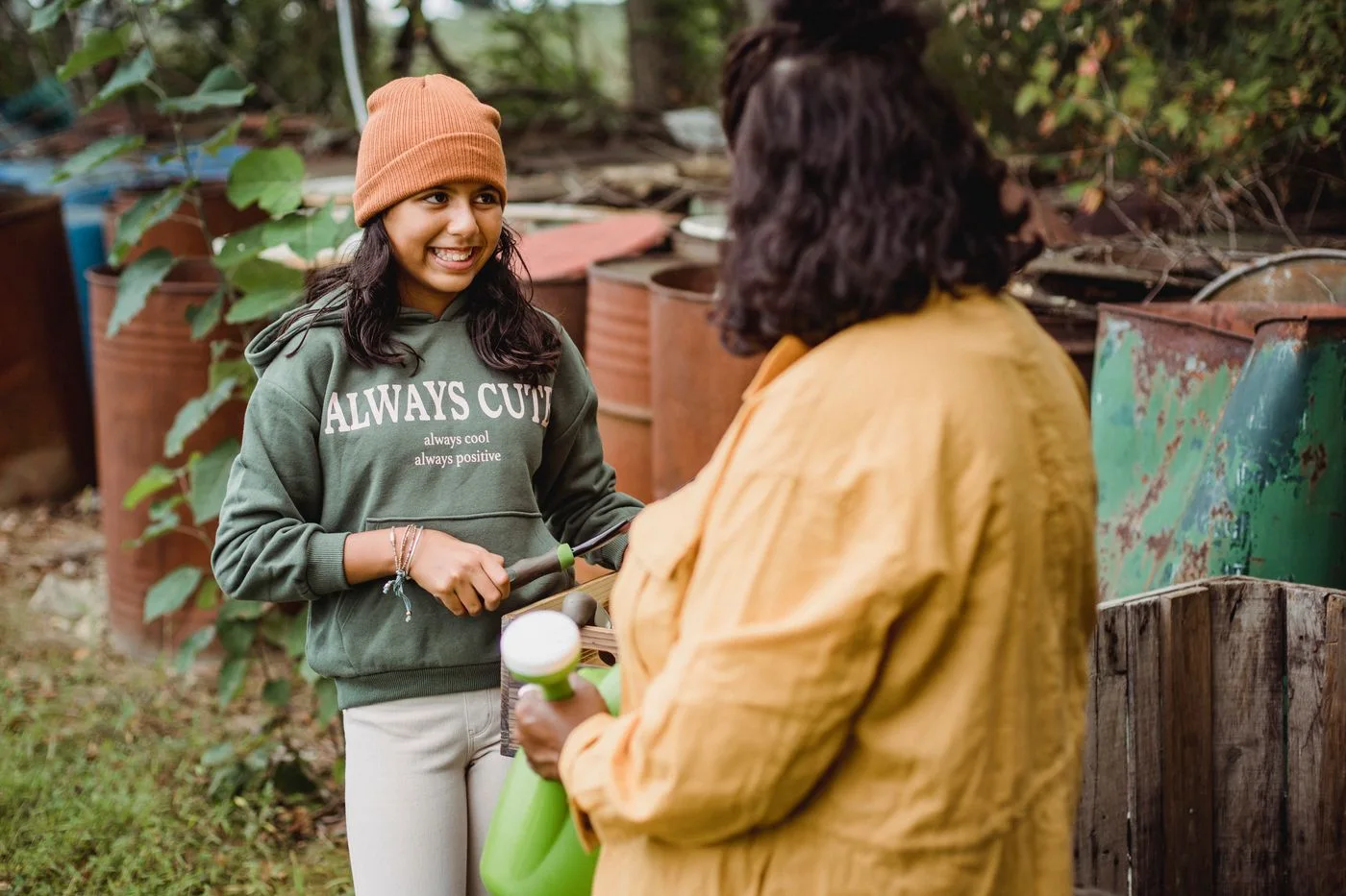 A mother and daughter standing outdoors with gardening tools